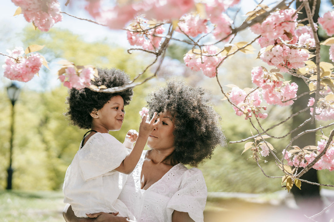 Mother holding baby with "Forget Flowers—Give Mom Peace of Mind This Mother's Day" life insurance blog headline.